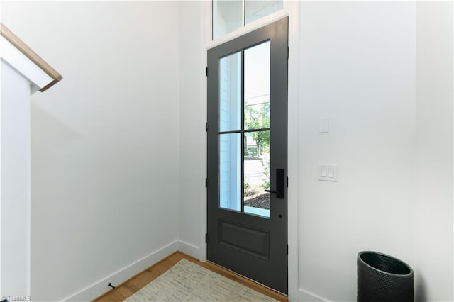 doorway to outside featuring baseboards and light wood-style floors