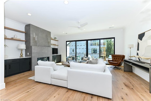 living area with a ceiling fan, light wood finished floors, a fireplace, and recessed lighting