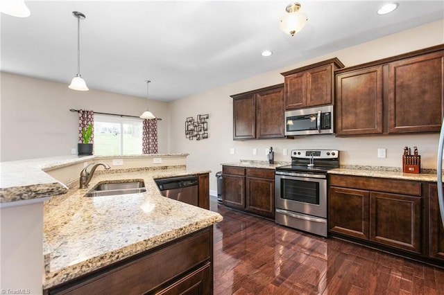 kitchen featuring dark brown cabinets, a sink, dark wood-style flooring, appliances with stainless steel finishes, and light stone counters