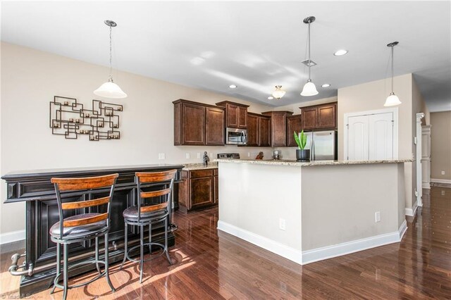 kitchen featuring dark brown cabinets, baseboards, appliances with stainless steel finishes, and a center island