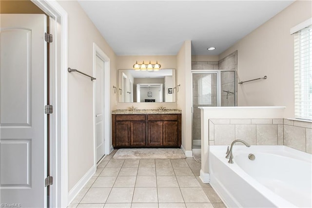 full bath with baseboards, a stall shower, tile patterned flooring, double vanity, and a garden tub