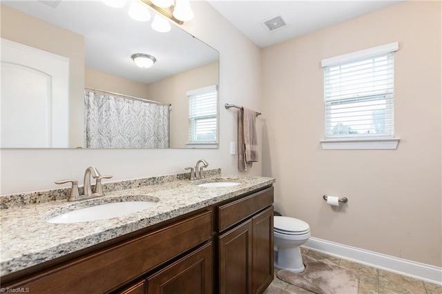 full bath featuring toilet, visible vents, baseboards, and a sink