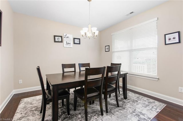 dining room featuring an inviting chandelier, baseboards, dark wood-type flooring, and visible vents