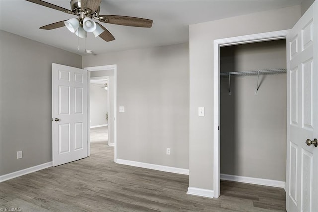 unfurnished bedroom featuring wood-type flooring, ceiling fan, and a closet