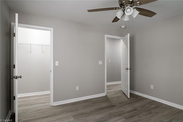 unfurnished bedroom with hardwood / wood-style flooring, ceiling fan, and a closet