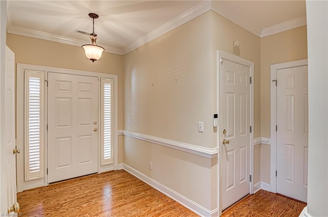 foyer featuring crown molding, a wealth of natural light, and light hardwood / wood-style flooring