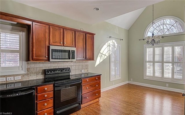 kitchen with tasteful backsplash, a chandelier, lofted ceiling, light hardwood / wood-style floors, and black appliances