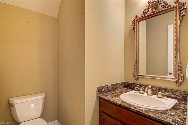 bathroom with vanity, toilet, and vaulted ceiling