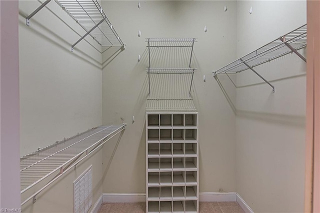 walk in closet featuring light colored carpet