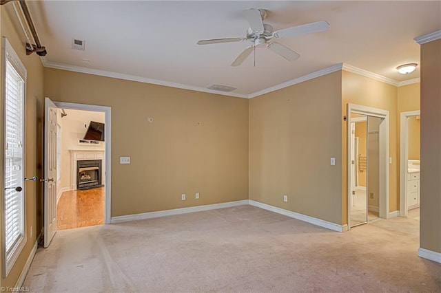 unfurnished bedroom featuring ceiling fan, light colored carpet, and ornamental molding