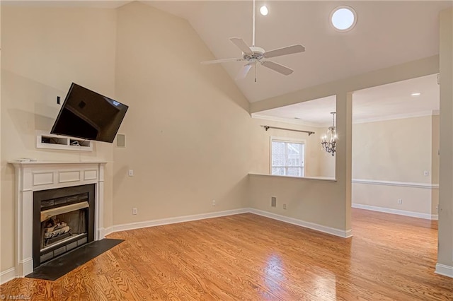 unfurnished living room with ornamental molding, ceiling fan with notable chandelier, light hardwood / wood-style floors, and lofted ceiling