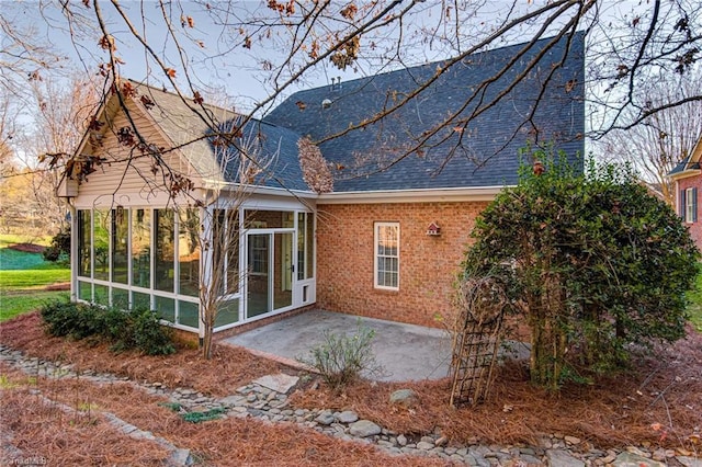 back of property featuring a sunroom and a patio