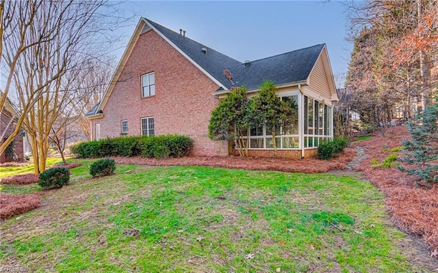 back of property with a lawn and a sunroom