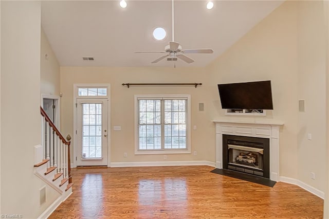 unfurnished living room featuring hardwood / wood-style flooring, high vaulted ceiling, and ceiling fan