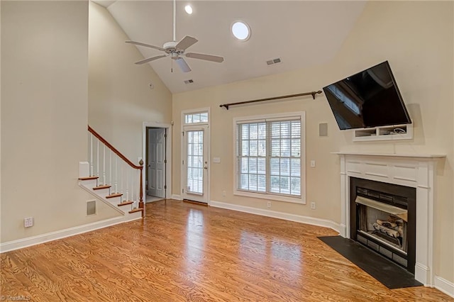 unfurnished living room featuring hardwood / wood-style floors, high vaulted ceiling, and ceiling fan