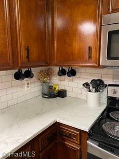 102 Aspen Ct, Winston-Salem, NC 27106 - kitchen with stainless steel appliances, light countertops, decorative backsplash, and brown cabinets