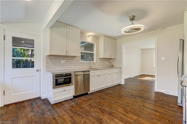 kitchen with white cabinets, decorative backsplash, stainless steel appliances, and sink