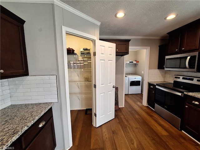 kitchen with stainless steel appliances, dark brown cabinets, independent washer and dryer, light stone countertops, and dark wood finished floors