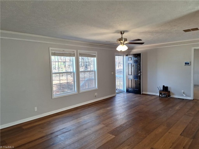 empty room with crown molding, dark wood finished floors, visible vents, a textured ceiling, and baseboards