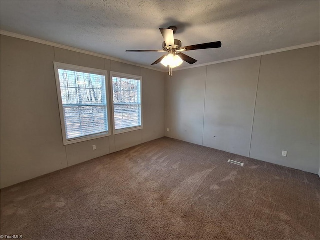 empty room with carpet, crown molding, and a textured ceiling