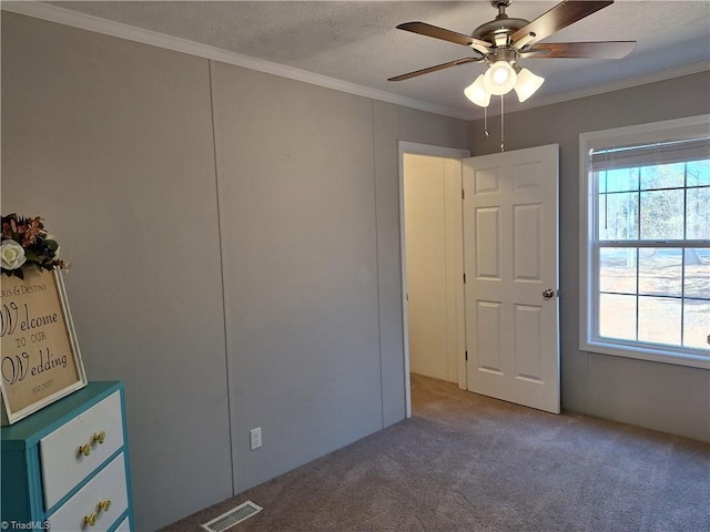 unfurnished bedroom featuring multiple windows, visible vents, and crown molding