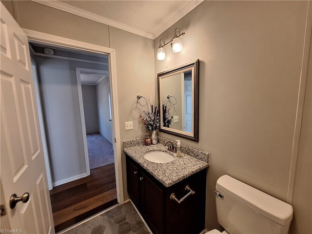 bathroom with toilet, wood finished floors, crown molding, and vanity