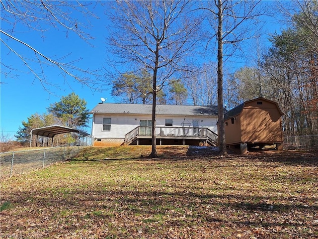 back of house with an outbuilding, fence, a storage unit, a wooden deck, and a carport