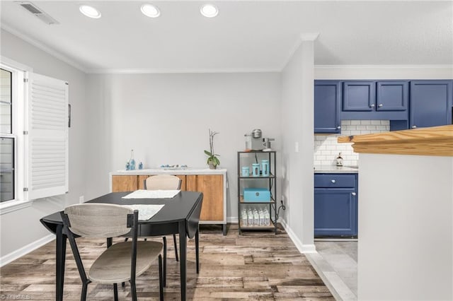 dining area with ornamental molding, light wood-type flooring, recessed lighting, and baseboards