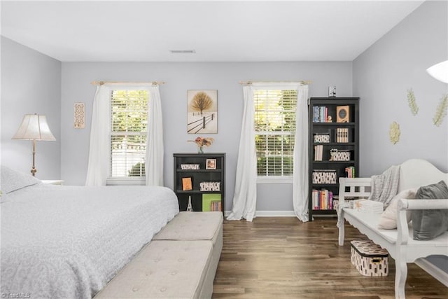 bedroom featuring multiple windows, wood finished floors, and baseboards