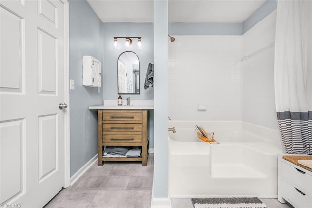 full bath featuring vanity, baseboards, and shower / tub combo