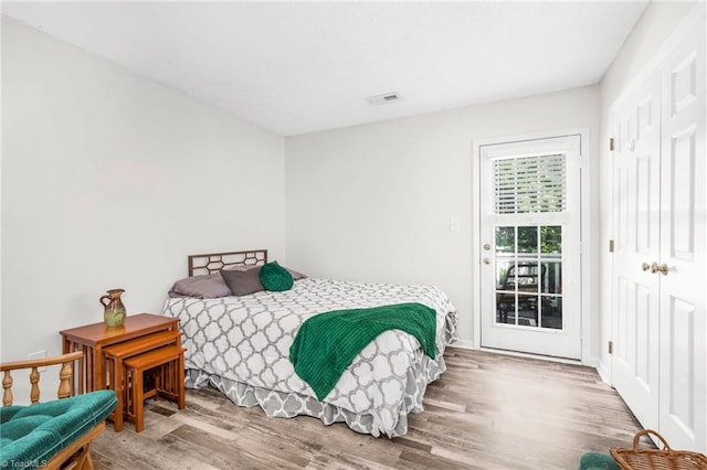 bedroom with wood finished floors and access to exterior