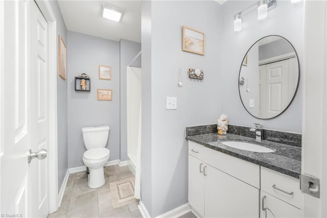 bathroom featuring toilet, vanity, baseboards, tile patterned floors, and a shower