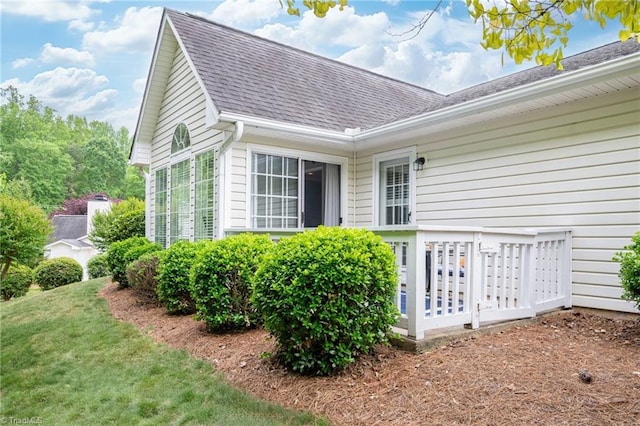 view of home's exterior featuring a lawn and roof with shingles