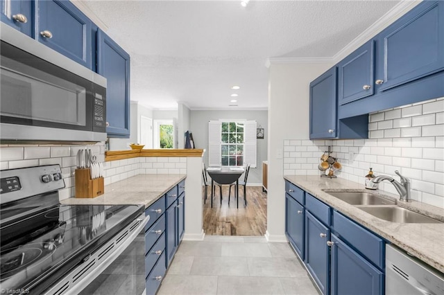 kitchen with stainless steel appliances, blue cabinets, a sink, a textured ceiling, and ornamental molding