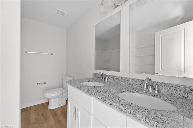 2154 E First St, Winston-Salem, NC 27101 - full bath with wood finished floors, toilet, double vanity, and baseboards