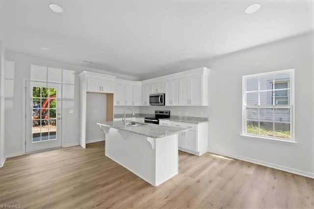 2154 E First St, Winston-Salem, NC 27101 - kitchen featuring stainless steel appliances, a sink, white cabinetry, and light wood-style flooring