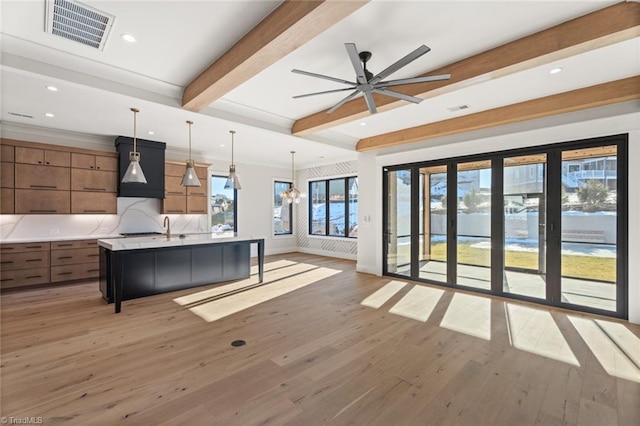 interior space featuring beamed ceiling, light wood-style flooring, visible vents, and baseboards