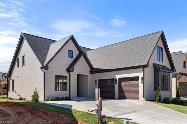 view of front of home featuring brick siding, concrete driveway, a garage, and roof with shingles