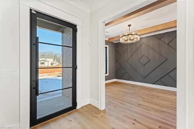 entrance foyer with beam ceiling, baseboards, an inviting chandelier, and wood finished floors