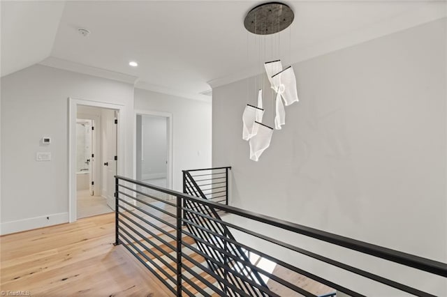 hall featuring an upstairs landing, ornamental molding, recessed lighting, light wood-style floors, and baseboards