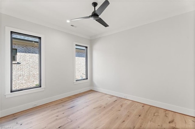 empty room featuring visible vents, baseboards, light wood-style flooring, and a ceiling fan