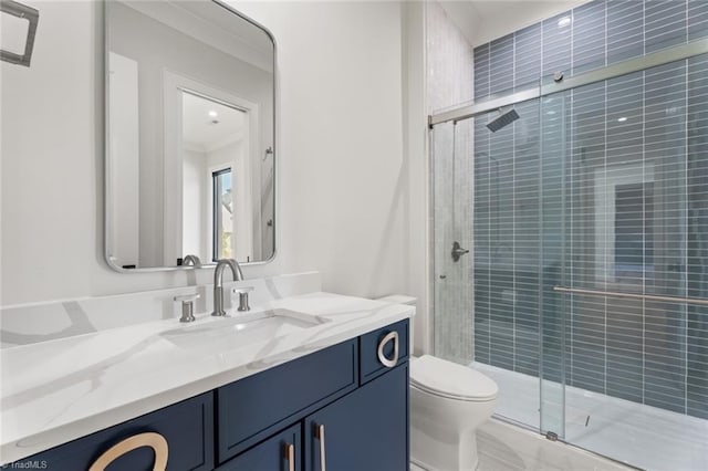 bathroom featuring toilet, a stall shower, vanity, and crown molding