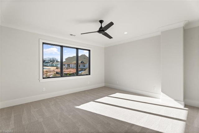 spare room with carpet floors, a ceiling fan, baseboards, and ornamental molding