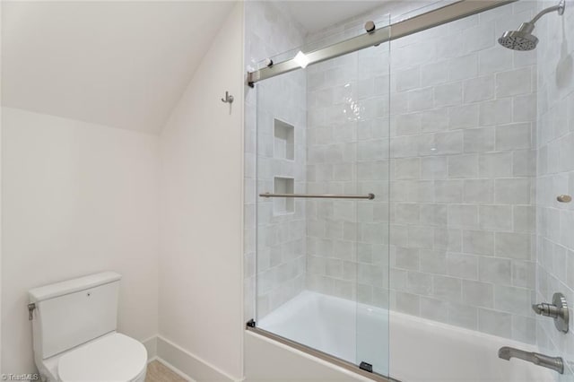 full bath with combined bath / shower with glass door, baseboards, toilet, and lofted ceiling