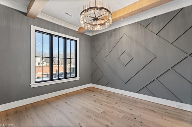 empty room with visible vents, beamed ceiling, wood finished floors, an inviting chandelier, and baseboards