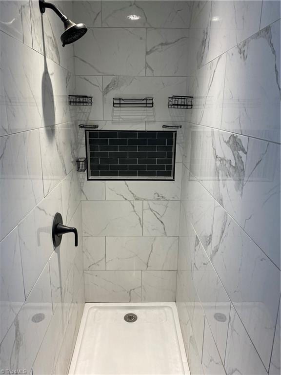 bathroom with a tile shower