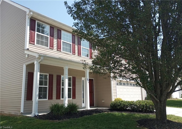 view of front facade featuring covered porch, a garage, and a front lawn