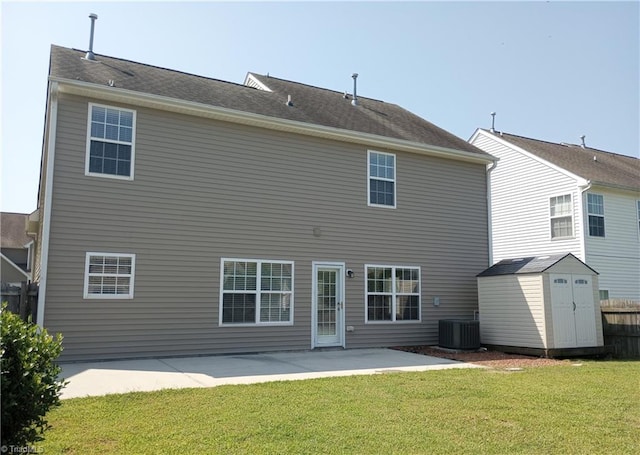 rear view of property featuring central AC unit, a lawn, a patio, and a shed