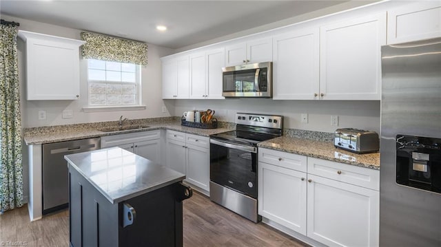 kitchen with sink, a center island, white cabinetry, and stainless steel appliances