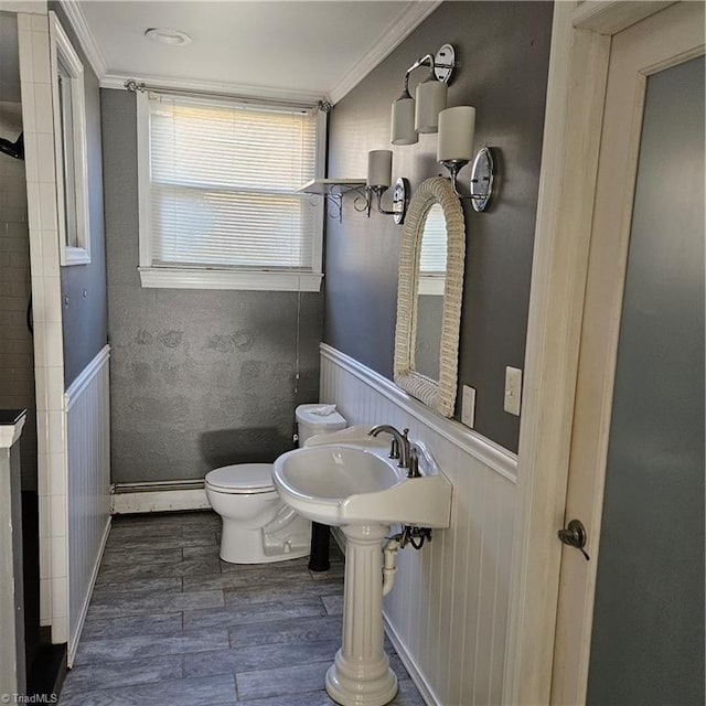 bathroom featuring ornamental molding, baseboard heating, sink, hardwood / wood-style flooring, and toilet